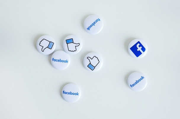 Facebook pin badges scattered on a white background