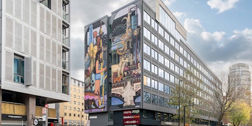 A London street scene overlooked by a mural 