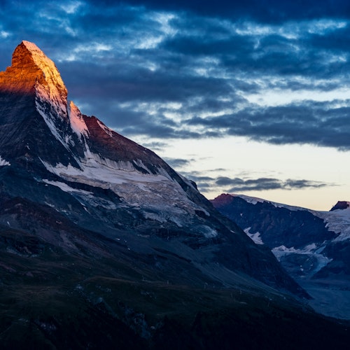 The sun-kissed snow-caps of a mountain