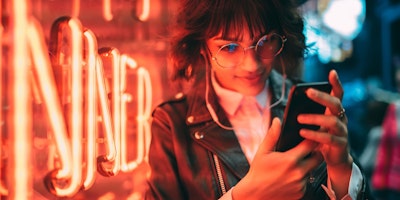 A young woman shops e-commerce on her mobile cell phone